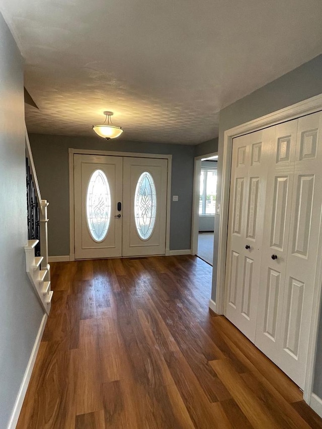 entrance foyer with stairway, baseboards, and wood finished floors