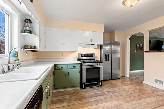 kitchen with visible vents, open shelves, a sink, under cabinet range hood, and appliances with stainless steel finishes