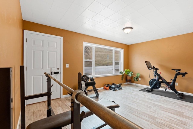 workout area featuring wood finished floors and baseboards