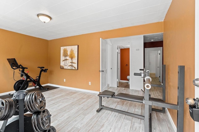 workout area featuring baseboards and wood finished floors