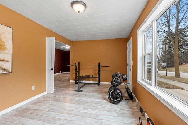 exercise room with visible vents, baseboards, and light wood-style flooring