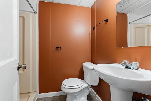 bathroom featuring a sink, visible vents, toilet, and walk in shower