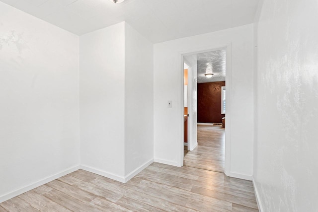 unfurnished room featuring light wood-type flooring and baseboards