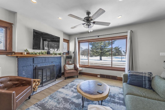 living room featuring visible vents, light wood-style flooring, a ceiling fan, recessed lighting, and a fireplace