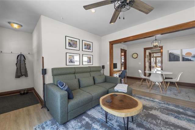 living area featuring ceiling fan, baseboards, and wood finished floors