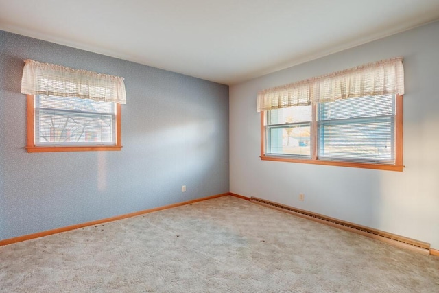 carpeted empty room featuring baseboards and baseboard heating