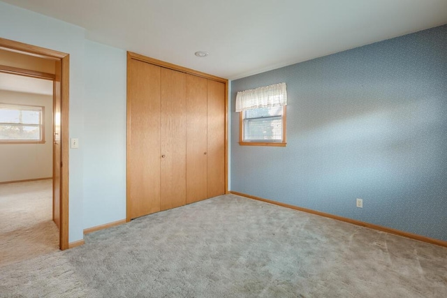 unfurnished bedroom with baseboards, a closet, and carpet floors