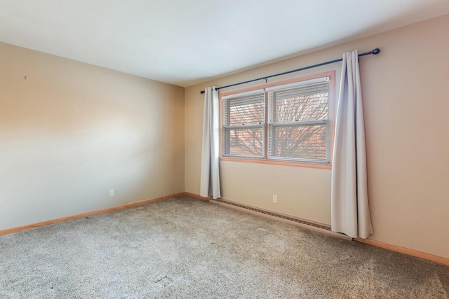 empty room with baseboard heating, baseboards, and carpet floors