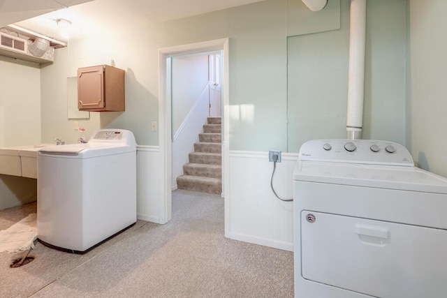 laundry area featuring washer and dryer, light colored carpet, visible vents, and wainscoting