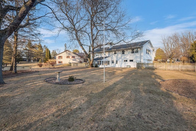 back of property with a yard and fence