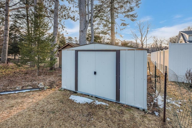 view of shed featuring fence