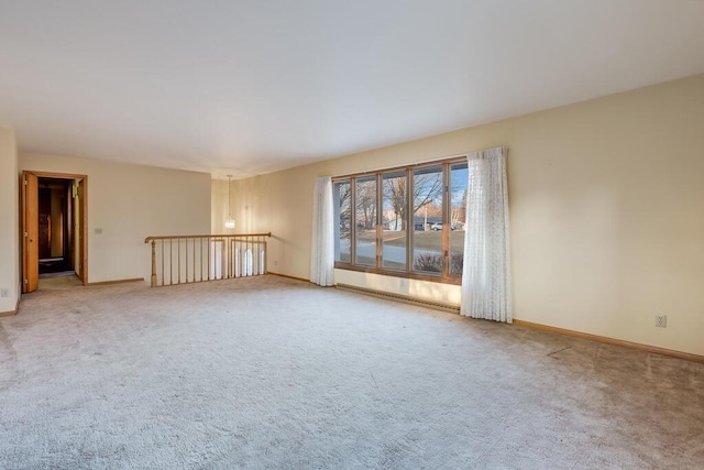 spare room featuring light colored carpet and baseboards