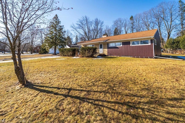 view of front of home featuring a front lawn and a chimney