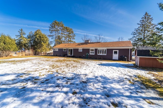 view of snow covered back of property