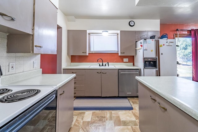 kitchen featuring a sink, stainless steel dishwasher, electric range oven, white fridge with ice dispenser, and light countertops