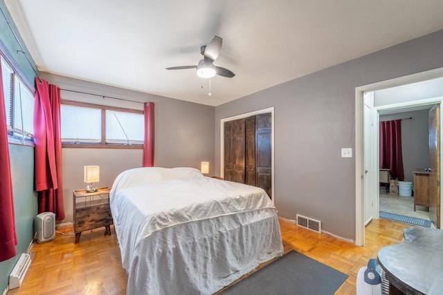 bedroom with visible vents, baseboards, baseboard heating, a closet, and a ceiling fan