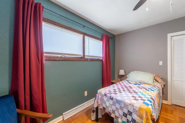 bedroom with a baseboard heating unit, baseboards, and a ceiling fan