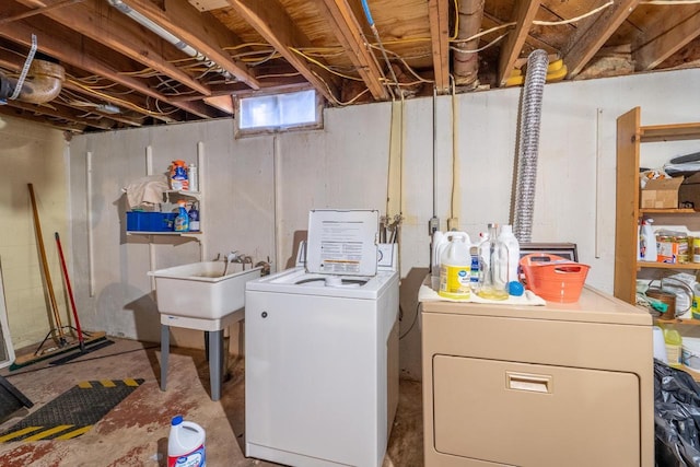 washroom featuring a sink, laundry area, and washing machine and clothes dryer