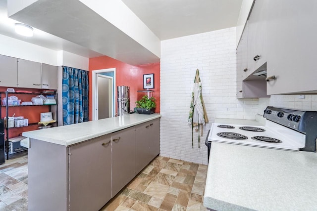 kitchen featuring electric range, gray cabinets, a peninsula, and light countertops