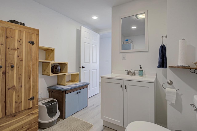 bathroom featuring recessed lighting, wood finished floors, and vanity