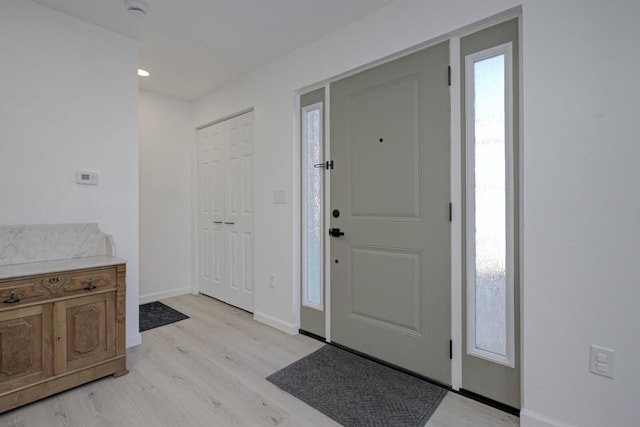 foyer with baseboards and light wood-type flooring