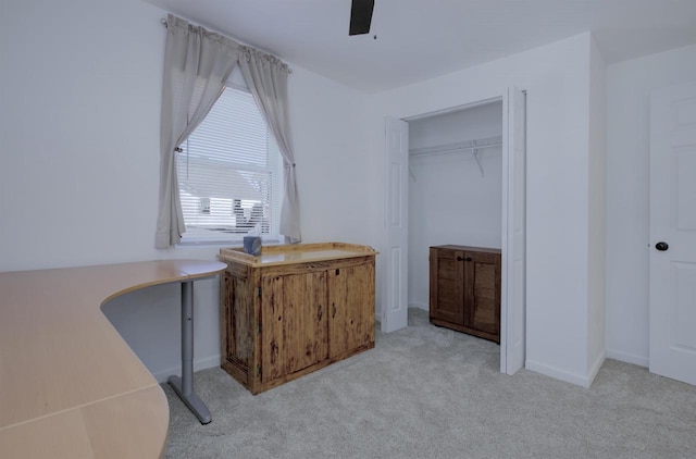 interior space with light carpet, a closet, and ceiling fan