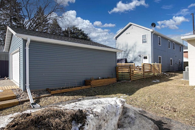 view of property exterior with a garage, an outbuilding, and fence