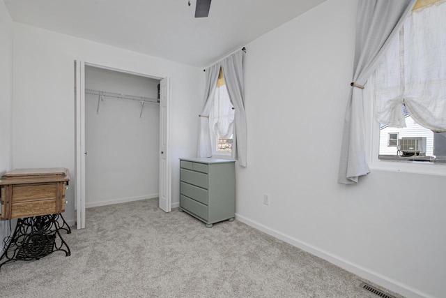 bedroom with a ceiling fan, visible vents, baseboards, a closet, and light colored carpet