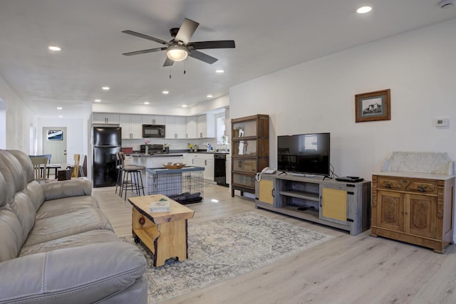 living area with recessed lighting and light wood-style floors