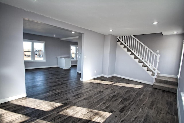 unfurnished living room with dark wood finished floors, stairway, recessed lighting, and baseboards