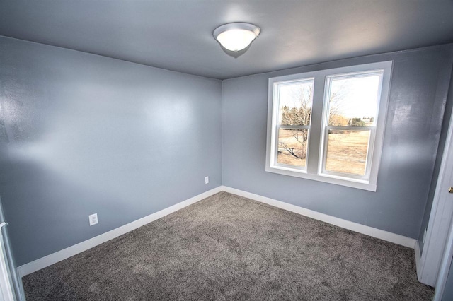 carpeted spare room featuring baseboards