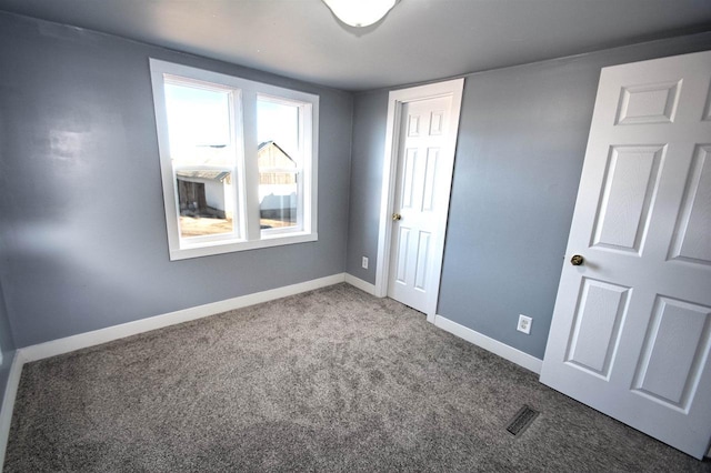 unfurnished bedroom with carpet flooring, visible vents, and baseboards