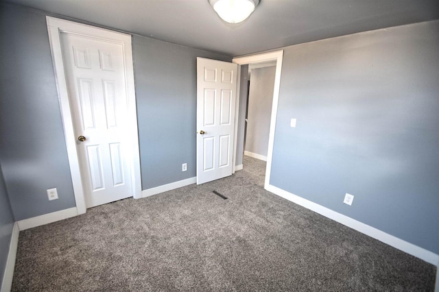 unfurnished bedroom featuring carpet flooring and baseboards