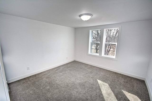 carpeted spare room featuring baseboards