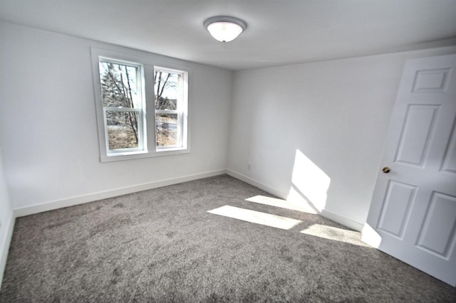 empty room with baseboards and carpet