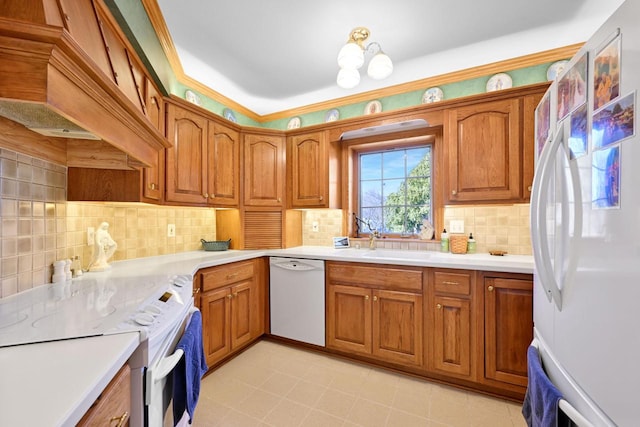 kitchen with a sink, white appliances, and brown cabinetry