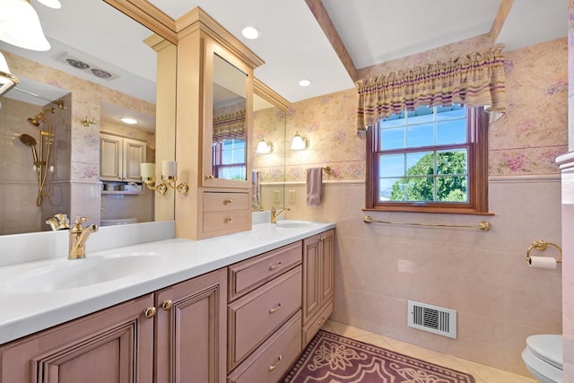 bathroom featuring a sink, visible vents, tile walls, and wallpapered walls