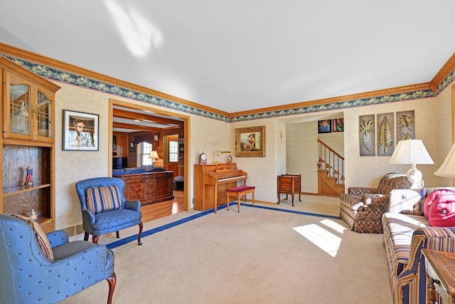 sitting room featuring wallpapered walls, stairs, carpet, and ornamental molding