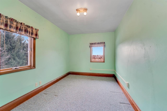 carpeted spare room featuring baseboards