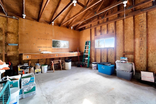 misc room featuring vaulted ceiling and unfinished concrete floors