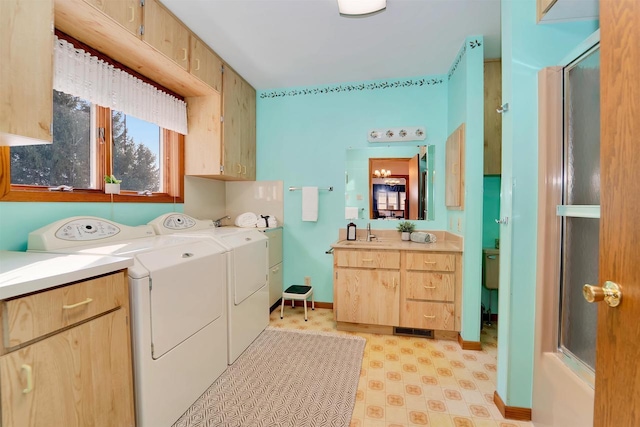 laundry room featuring washer and dryer, a sink, cabinet space, baseboards, and light floors