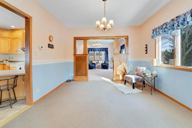 sitting room with a notable chandelier, light colored carpet, and baseboards