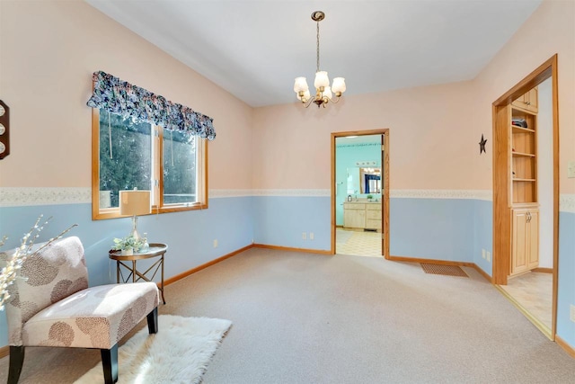 sitting room featuring a notable chandelier, carpet flooring, and baseboards