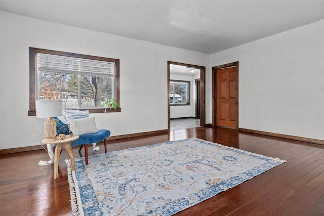 living area with plenty of natural light, baseboards, and hardwood / wood-style flooring