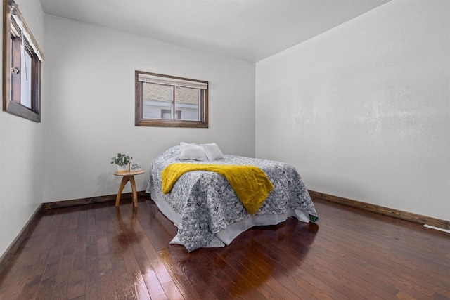 bedroom featuring dark wood finished floors, multiple windows, and baseboards