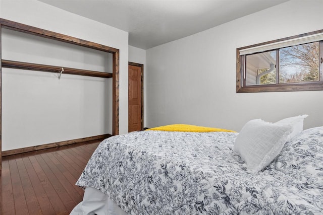 bedroom with a closet, baseboards, and hardwood / wood-style floors