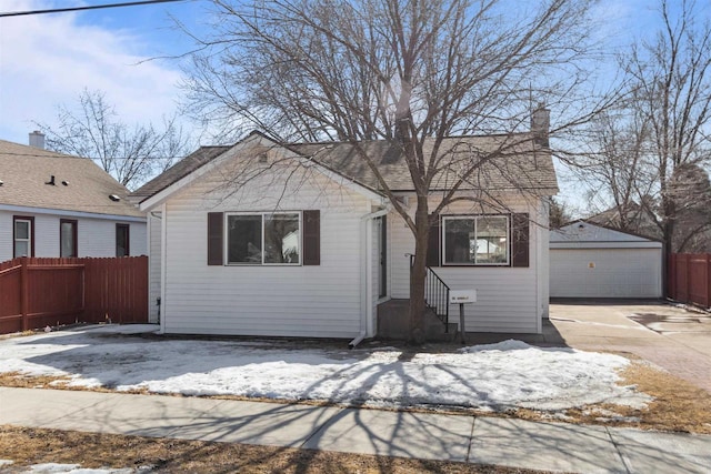 view of front of home featuring entry steps, an outbuilding, fence, and a detached garage