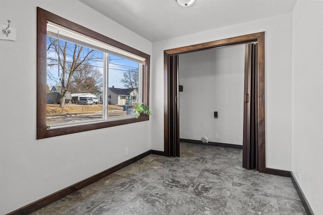 unfurnished room with baseboards