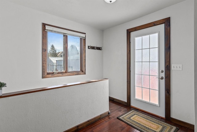 doorway featuring dark wood finished floors and baseboards