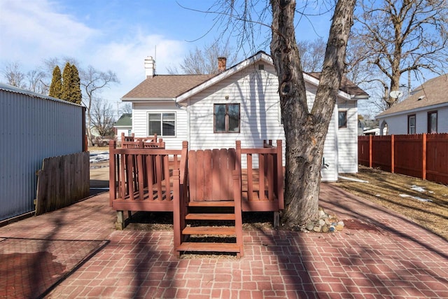 wooden terrace with decorative driveway and fence